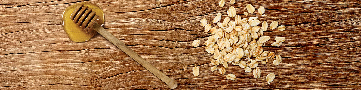 Holz Schneidebrett mit Honiglöffel und Haferflocken